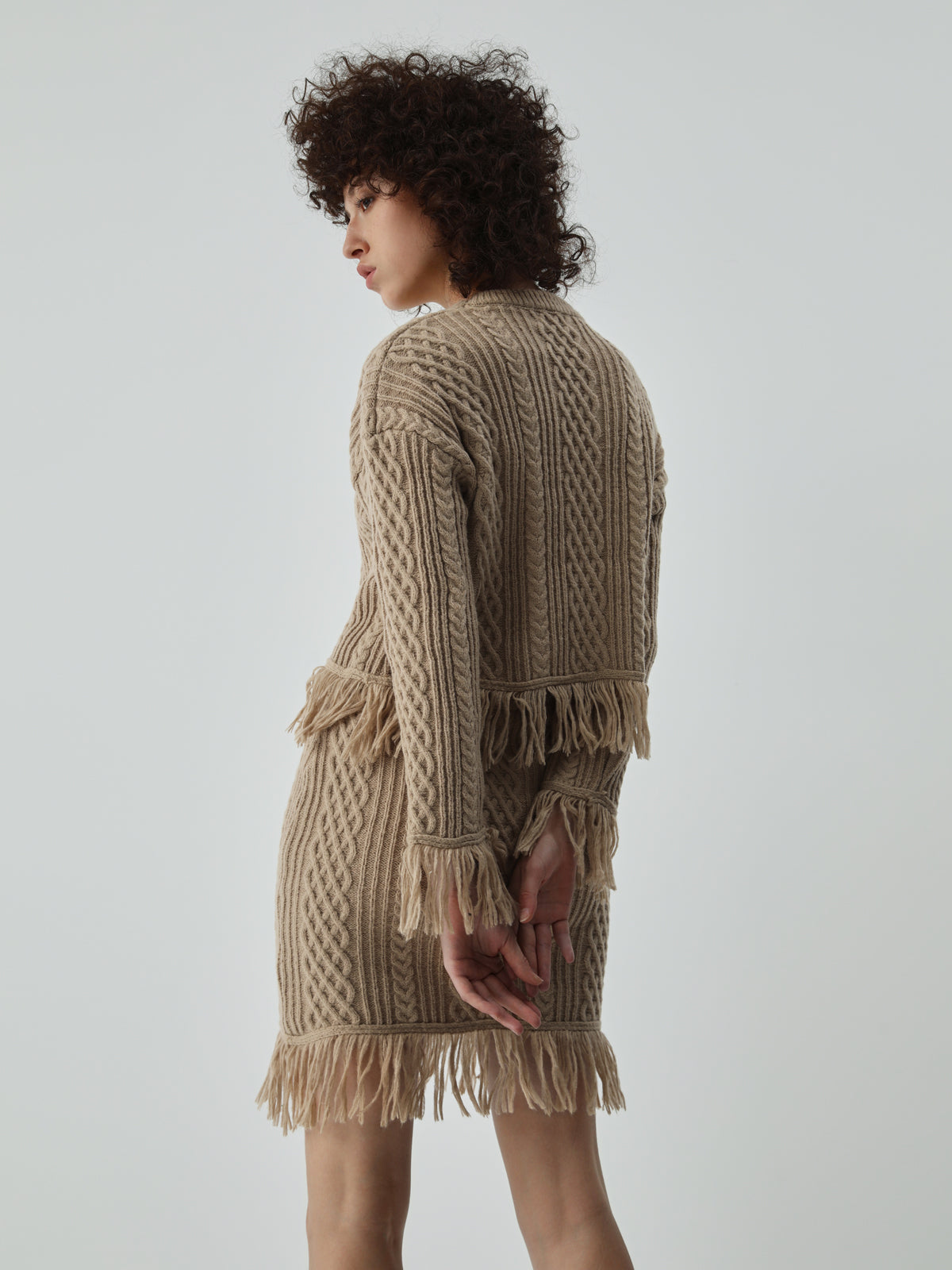 semble jupe et haut en tricot à torsades avec ourlet à franges à manches longues
